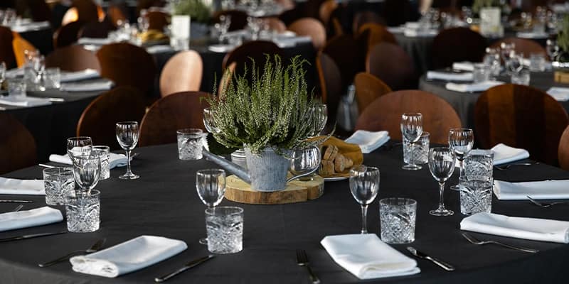 Der Blick auf fein gedeckte Tische mit Kristall und Silberbesteck, die für die Veranstaltungsbesucher vorbereitet sind